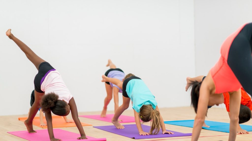 Un groupe d'enfants faisant du yoga pour la gestion du stress.